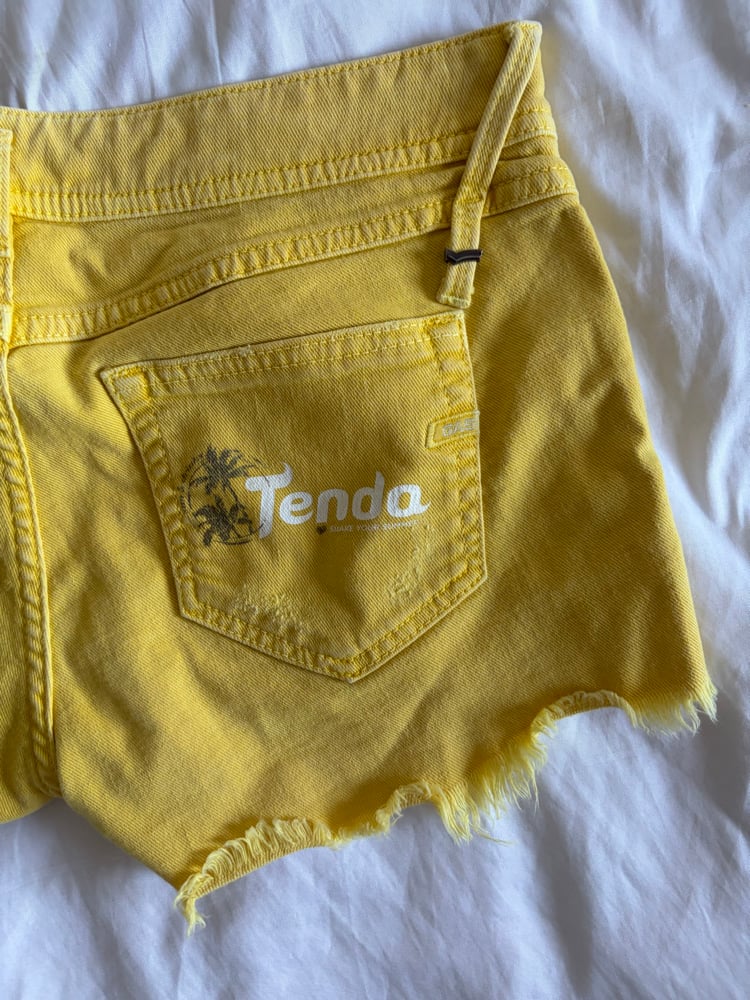 Vintage Y2K low rise yellow shorts with graphic and stud details