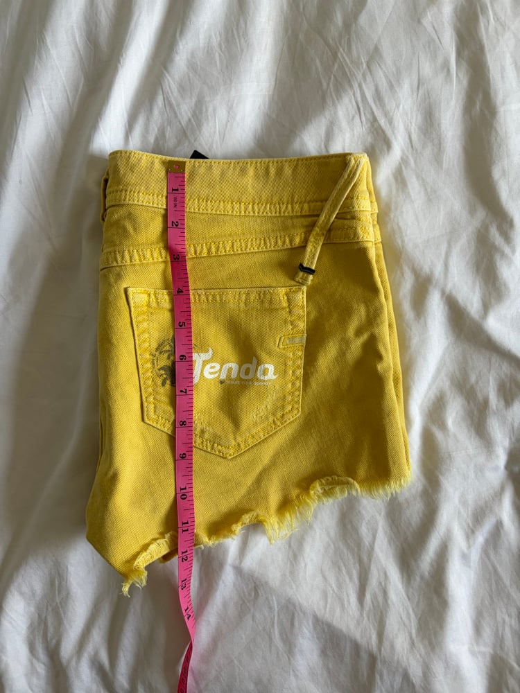 Vintage Y2K low rise yellow shorts with graphic and stud details