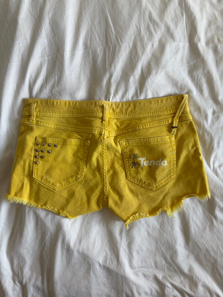 Vintage Y2K low rise yellow shorts with graphic and stud details