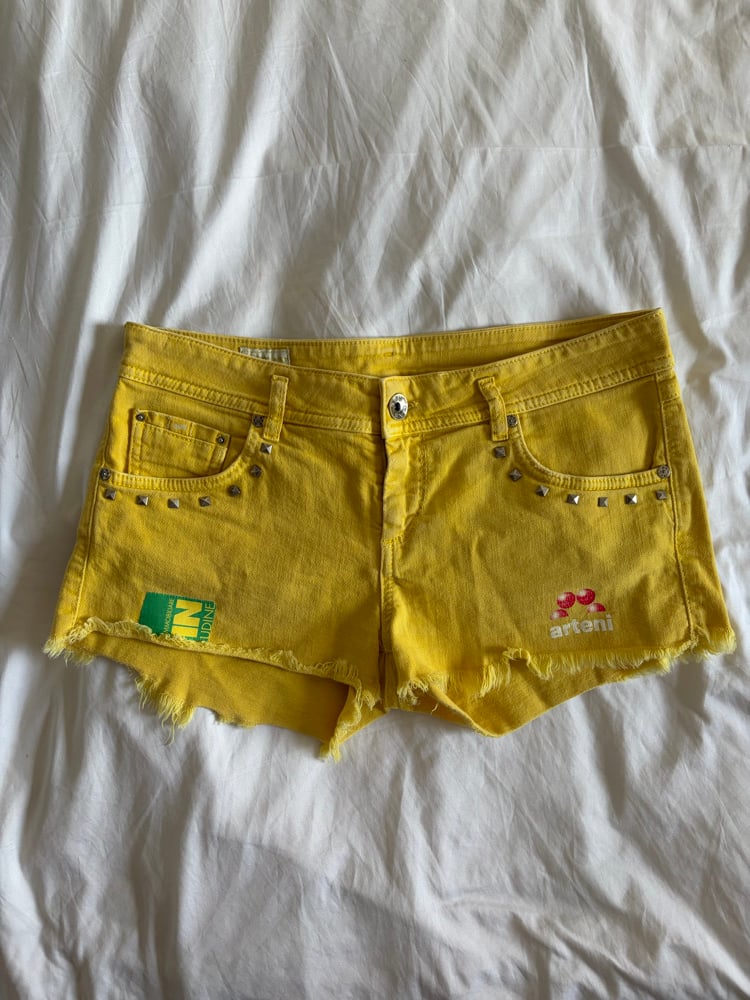 Vintage Y2K low rise yellow shorts with graphic and stud details