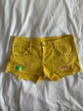 Vintage Y2K low rise yellow shorts with graphic and stud details